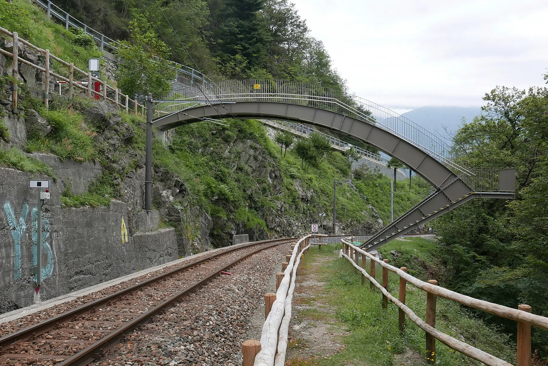 Il binario della ferrovia Vigezzina con il ponte pedonale ad arco sopra i binari