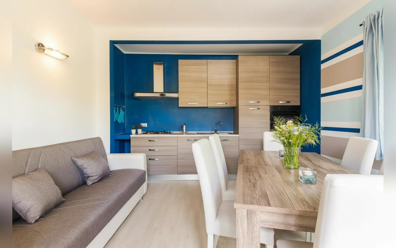 La cucina completa con la parete blu e il tavolo